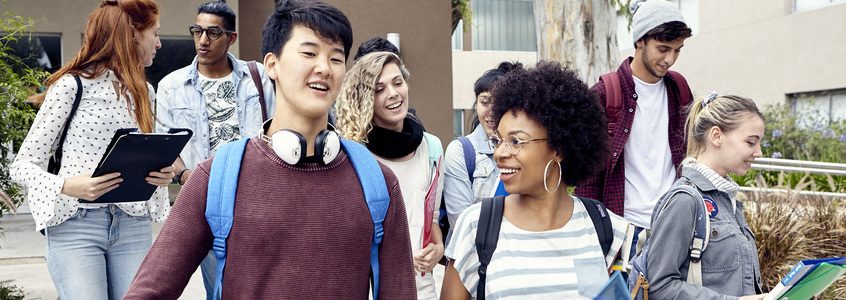 Young diversity friends students walking in a university campus