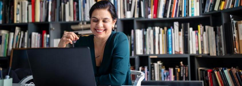 Businesswoman looking at her laptop and smiling Clearinghouse Activates eTranscripts on PowerCampus by Ellucian